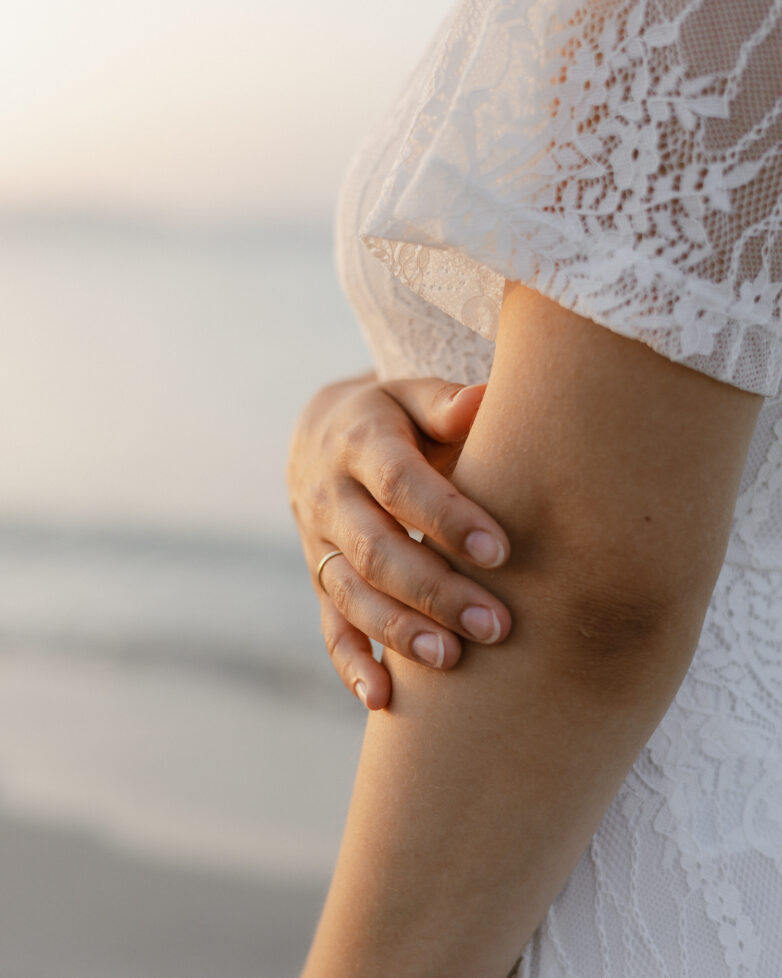 Hand mit Ring auf Brautarm